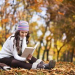 beautiful girl with book in the autumn park